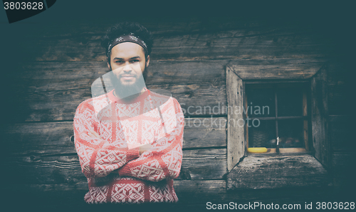 Image of portrait of young hipster in front of wooden house