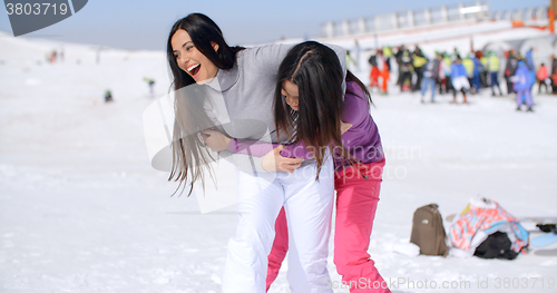 Image of Two playful woman frolicking in the snow