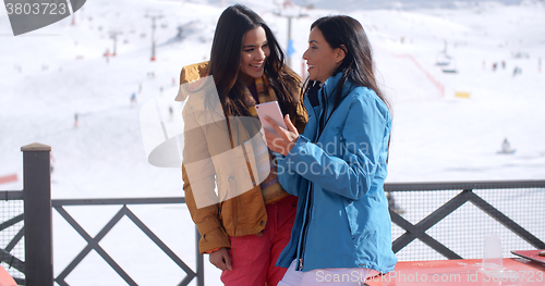 Image of Two smiling young women checking a phone
