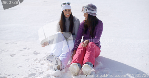 Image of Two young women sitting chatting in the snow