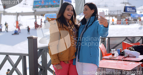 Image of Laughing friends taking selfie at a ski resort