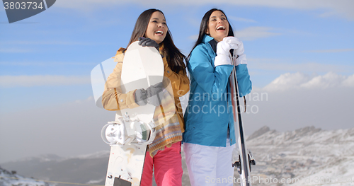 Image of Two young woman with their snowboards