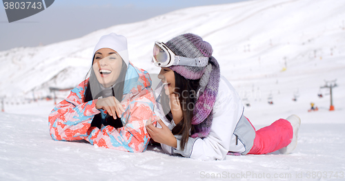 Image of Laughing skiers laying on the ground