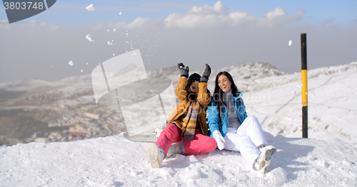 Image of Two young women having fun in winter snow
