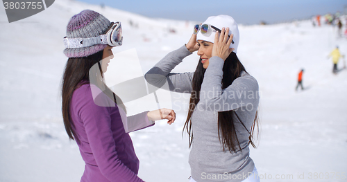 Image of Two stylish young woman chatting at a ski resort