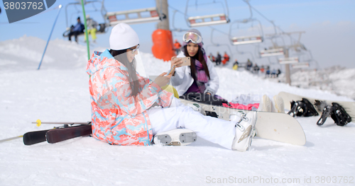 Image of Two attractive female snowboarders
