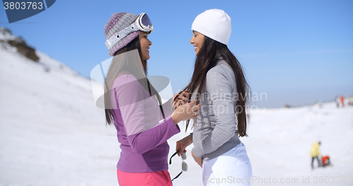 Image of Two attractive young women chatting in the snow