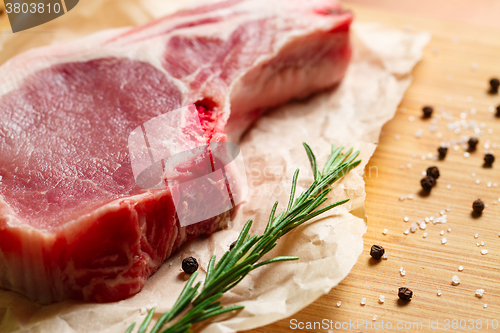 Image of Pieces of crude meat with rosemary and spices