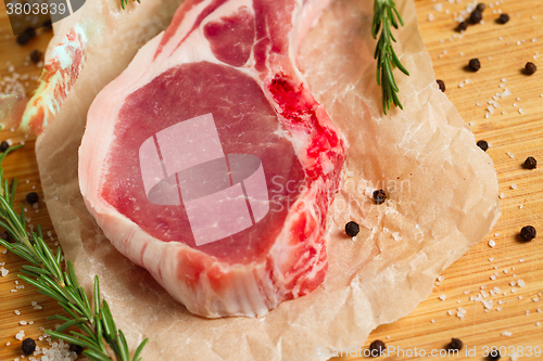 Image of Pieces of crude meat with rosemary and spices