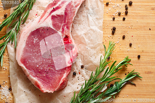 Image of Pieces of crude meat with rosemary and spices