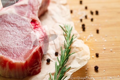 Image of Pieces of crude meat with rosemary and spices