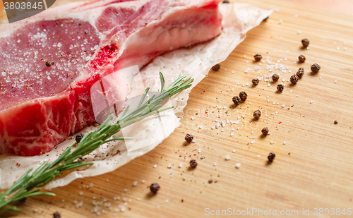 Image of Pieces of crude meat with rosemary and spices