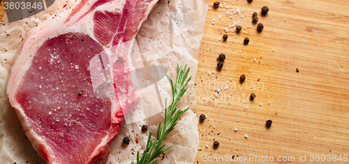 Image of Pieces of crude meat with rosemary and spices