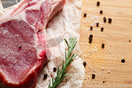 Image of Pieces of crude meat with rosemary and spices