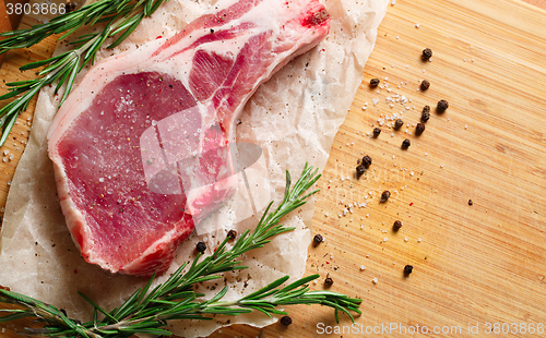 Image of Pieces of crude meat with rosemary and spices