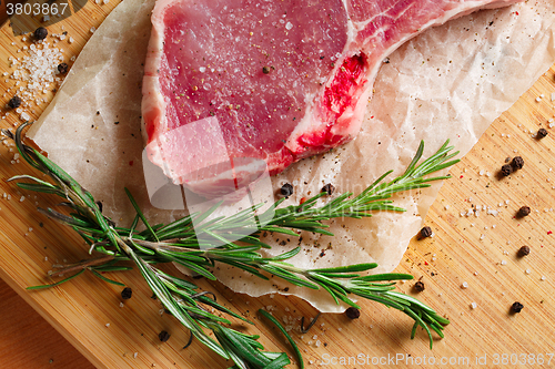 Image of Pieces of crude meat with rosemary and spices