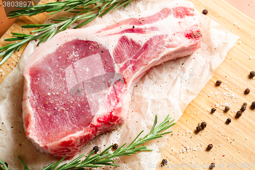 Image of Pieces of crude meat with rosemary and spices