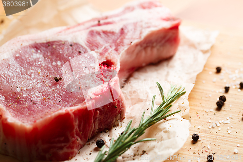 Image of Pieces of crude meat with rosemary and spices