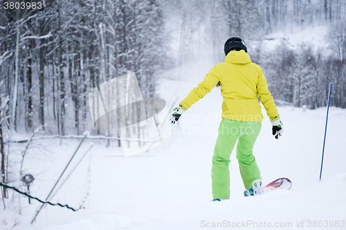 Image of Snowboarder riding on background beautiful mountain landscape