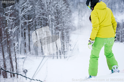 Image of Snowboarder standing on background beautiful mountain landscape