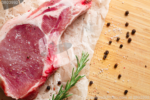 Image of Pieces of crude meat with rosemary and spices