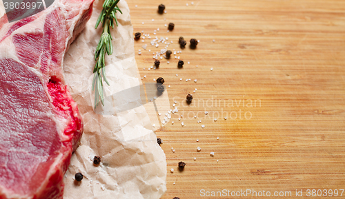 Image of Pieces of crude meat with rosemary and spices