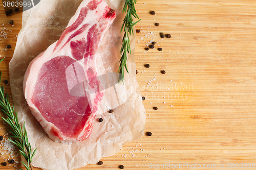 Image of Pieces of crude meat with rosemary and spices