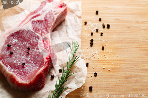 Image of Pieces of crude meat with rosemary and spices