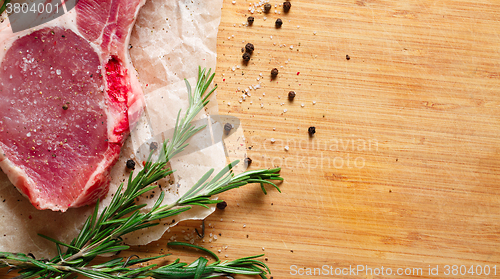 Image of Pieces of crude meat with rosemary and spices