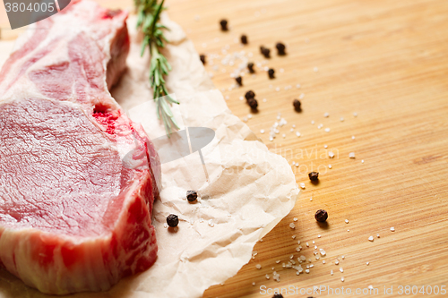 Image of Pieces of crude meat with rosemary and spices