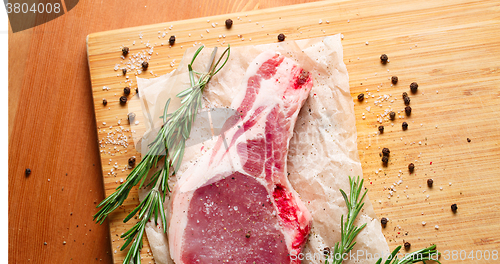 Image of Pieces of crude meat with rosemary and spices