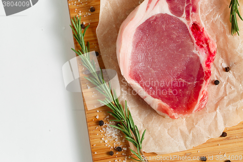 Image of Pieces of crude meat with rosemary and spices