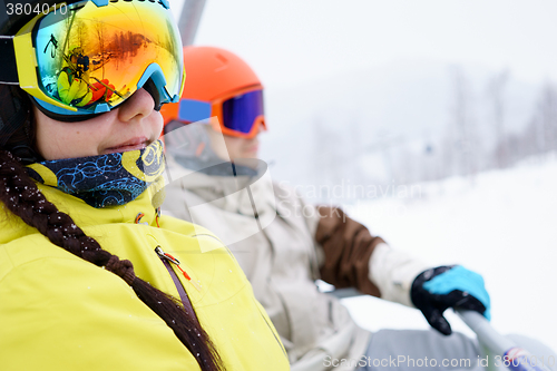 Image of Couple sitting on chairlift in mountain resorts.