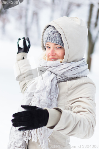 Image of Girl snowball fighting in winter time.