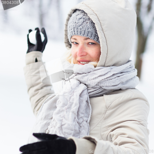 Image of Girl snowball fighting in winter time.