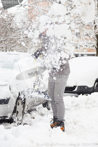 Image of Man shoveling snow in winter.