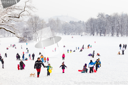 Image of Winter fun, snow, family sledding at winter time.