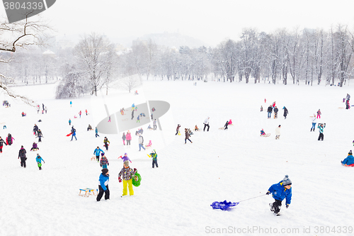 Image of Winter fun, snow, family sledding at winter time.