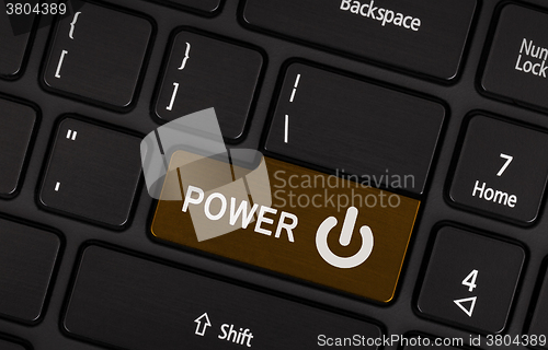 Image of Brown power button on a black laptop keyboard