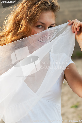 Image of Attractive woman holding white scarf