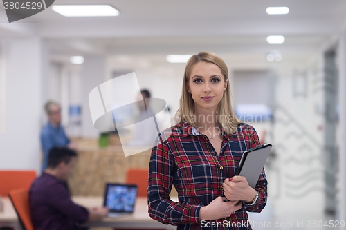 Image of portrait of young business woman at office with team in backgrou