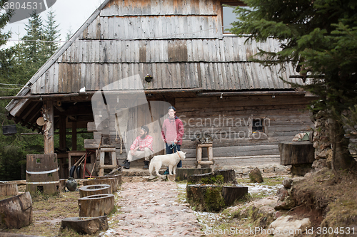 Image of frineds together in front of old wooden house