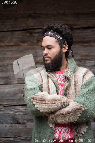 Image of portrait of young hipster in front of wooden house