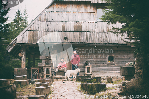 Image of frineds together in front of old wooden house