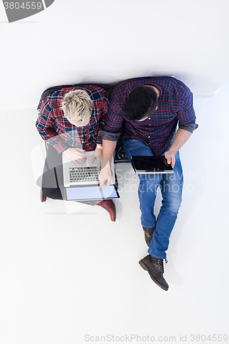 Image of top view of  couple working on laptop computer at startup office