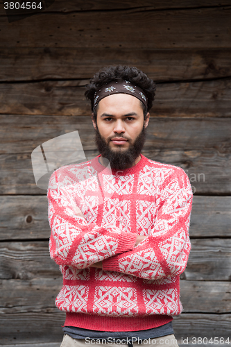 Image of portrait of young hipster in front of wooden house