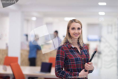 Image of portrait of young business woman at office with team in backgrou