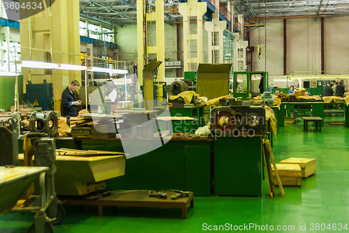 Image of Elderly mechanic works in shop