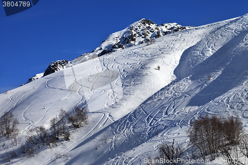 Image of Off-piste slope with track from ski and snowboard on sunny day