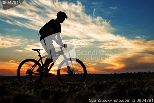 Image of Silhouette of a man on muontain-bike